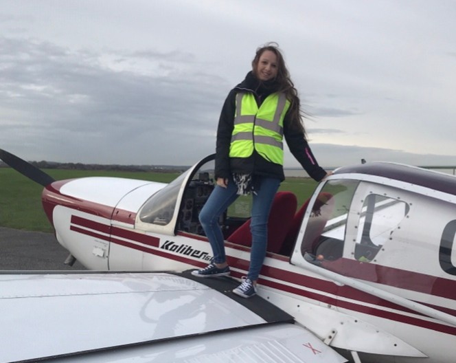 Woman stood next to aeroplane