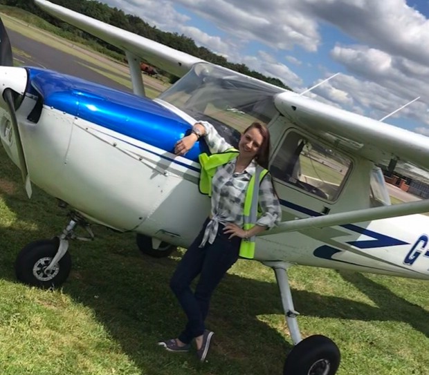 Woman stood next to aeroplane